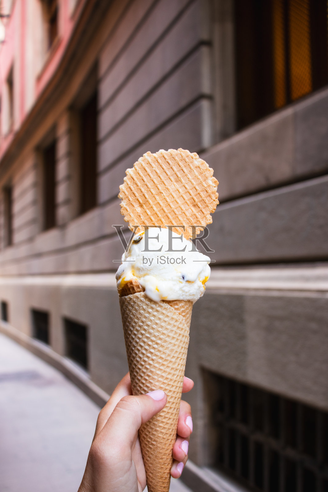 冰淇淋甜筒日，9月22日，年轻女性左手拿着美味的冰淇淋，8月31日，在外面吃照片摄影图片