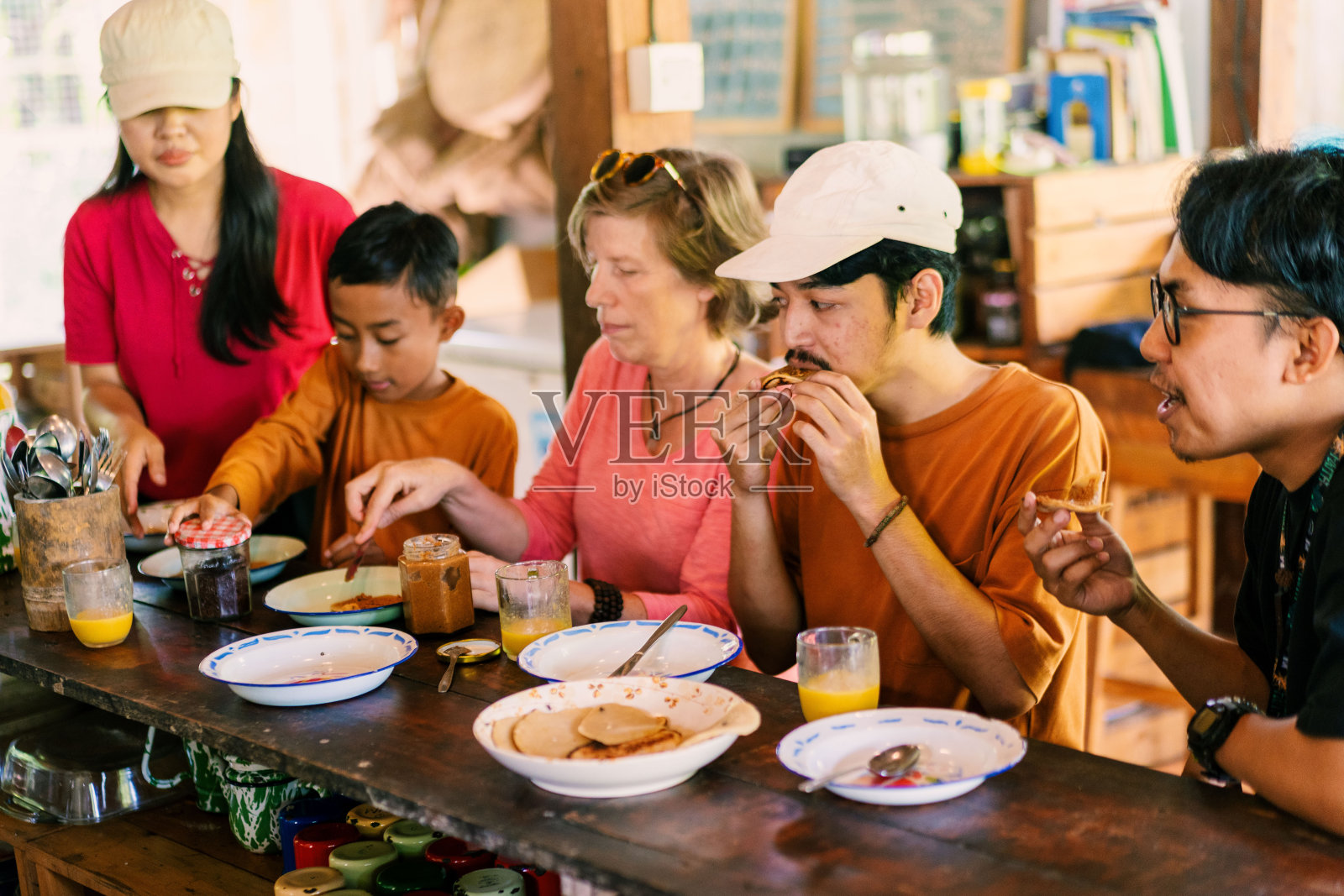 一群不同的朋友在木制的厨房餐桌上享用传统的家常煎饼小吃照片摄影图片