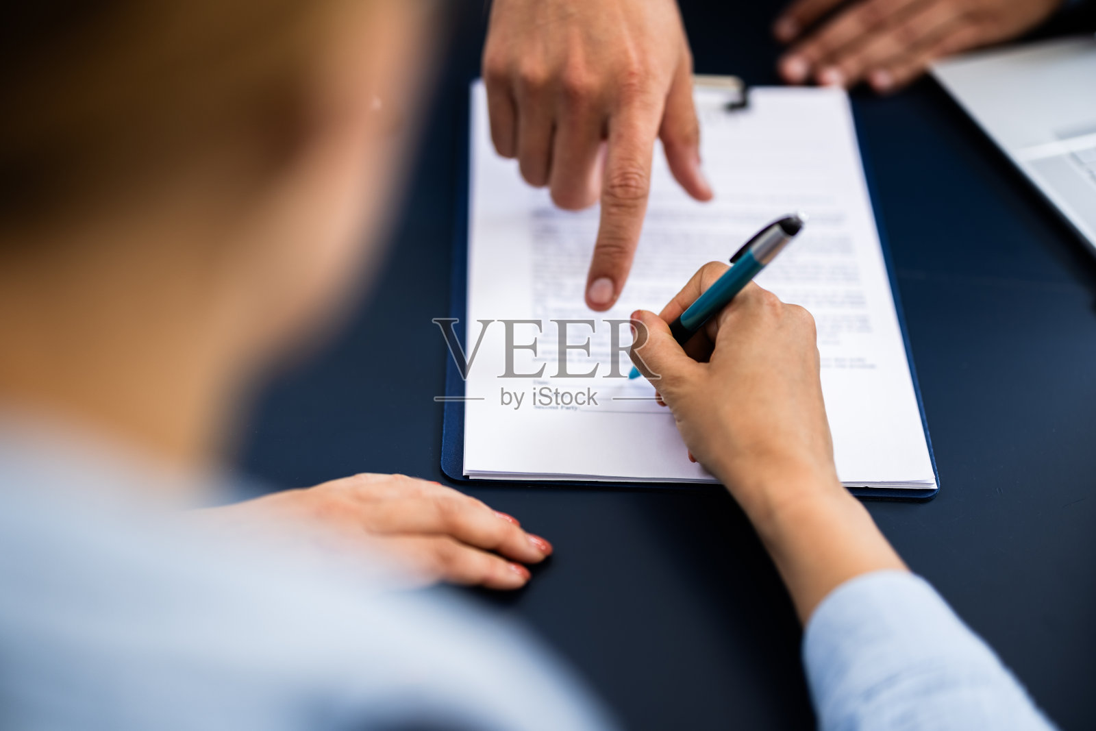 用金笔在文件上签字的人面前指指点点照片摄影图片