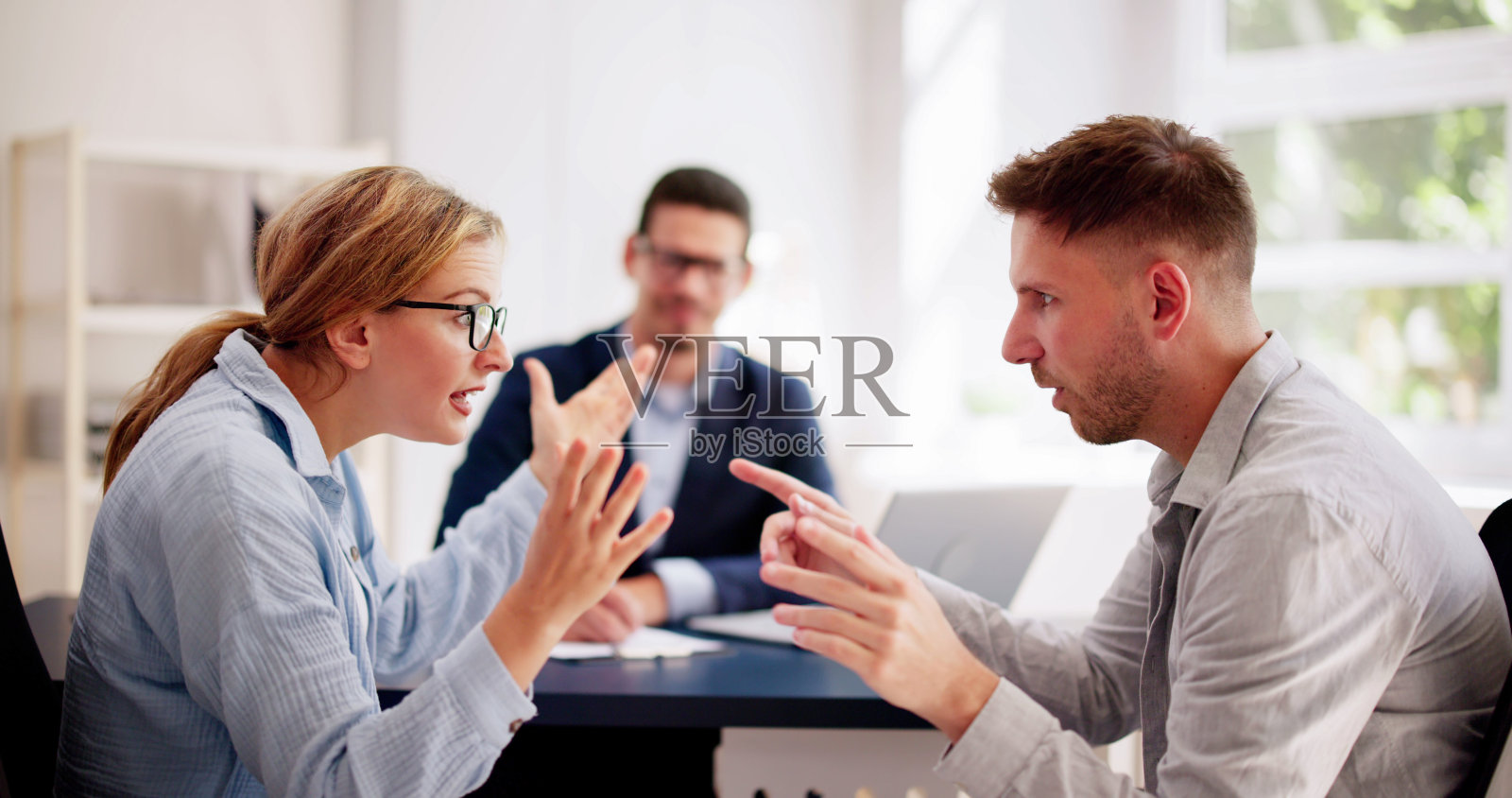 专业律师调解一对年轻的西班牙裔夫妇之间紧张的争吵照片摄影图片