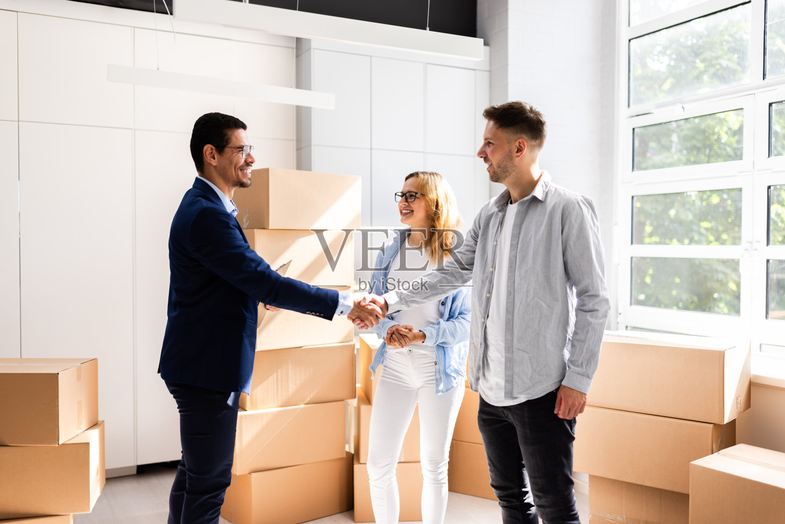 幸福的夫妇庆祝完成与房地产经纪人的交易照片摄影图片