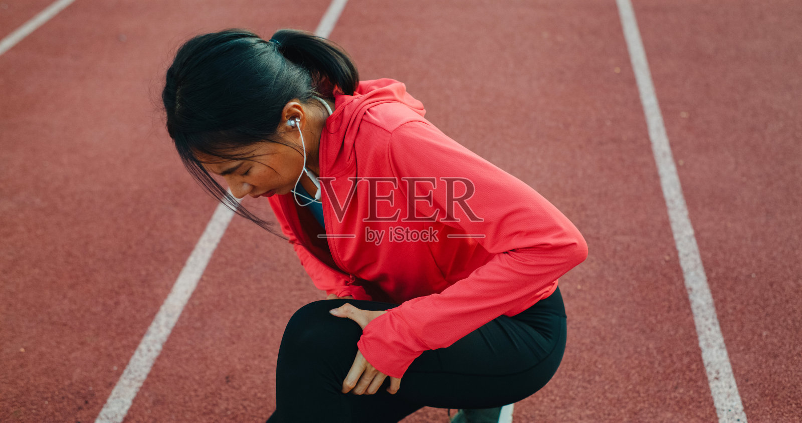 年轻的亚洲女运动员在户外训练时腿部受伤。健康的锻炼。照片摄影图片