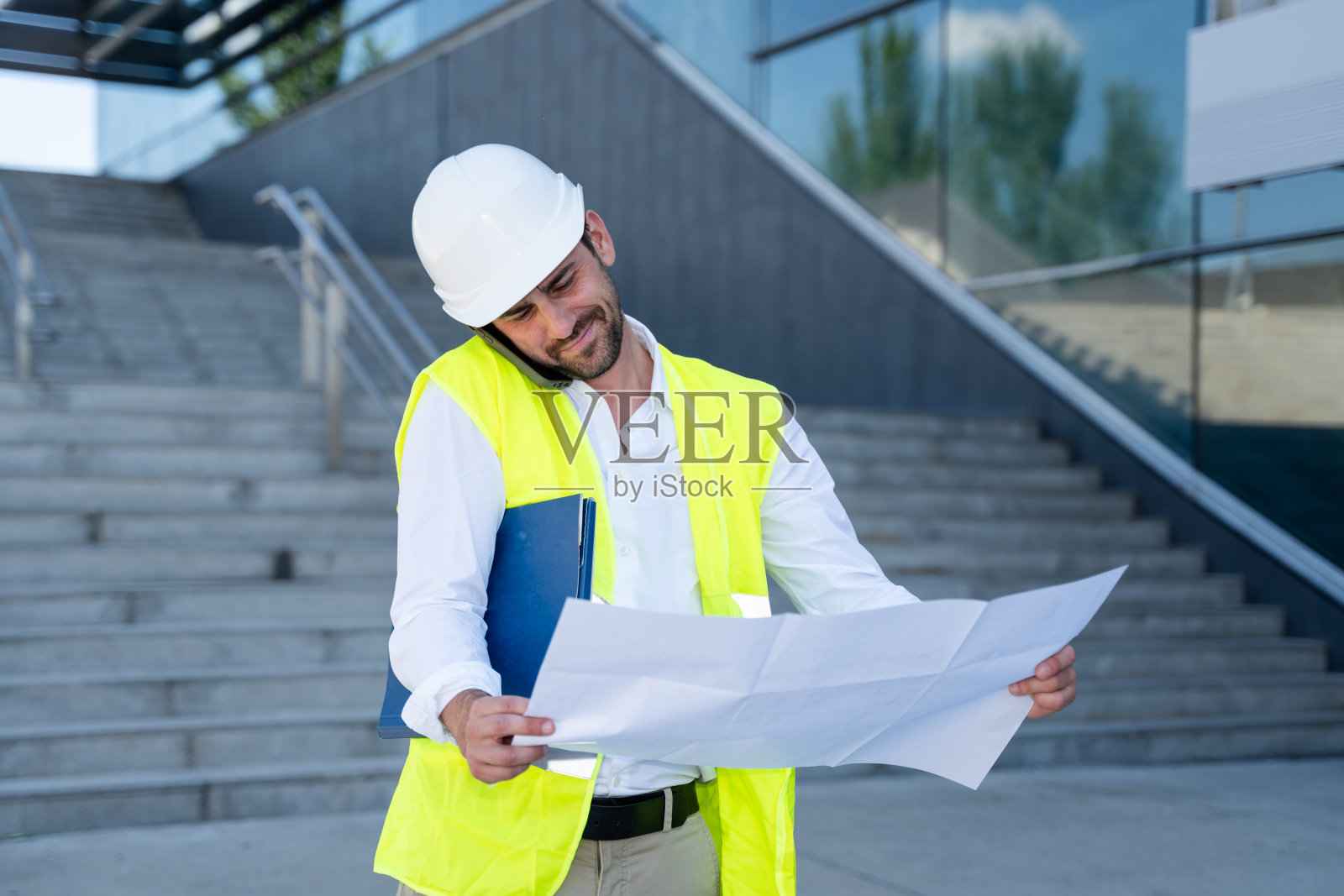 建筑师拿着蓝图在打电话照片摄影图片