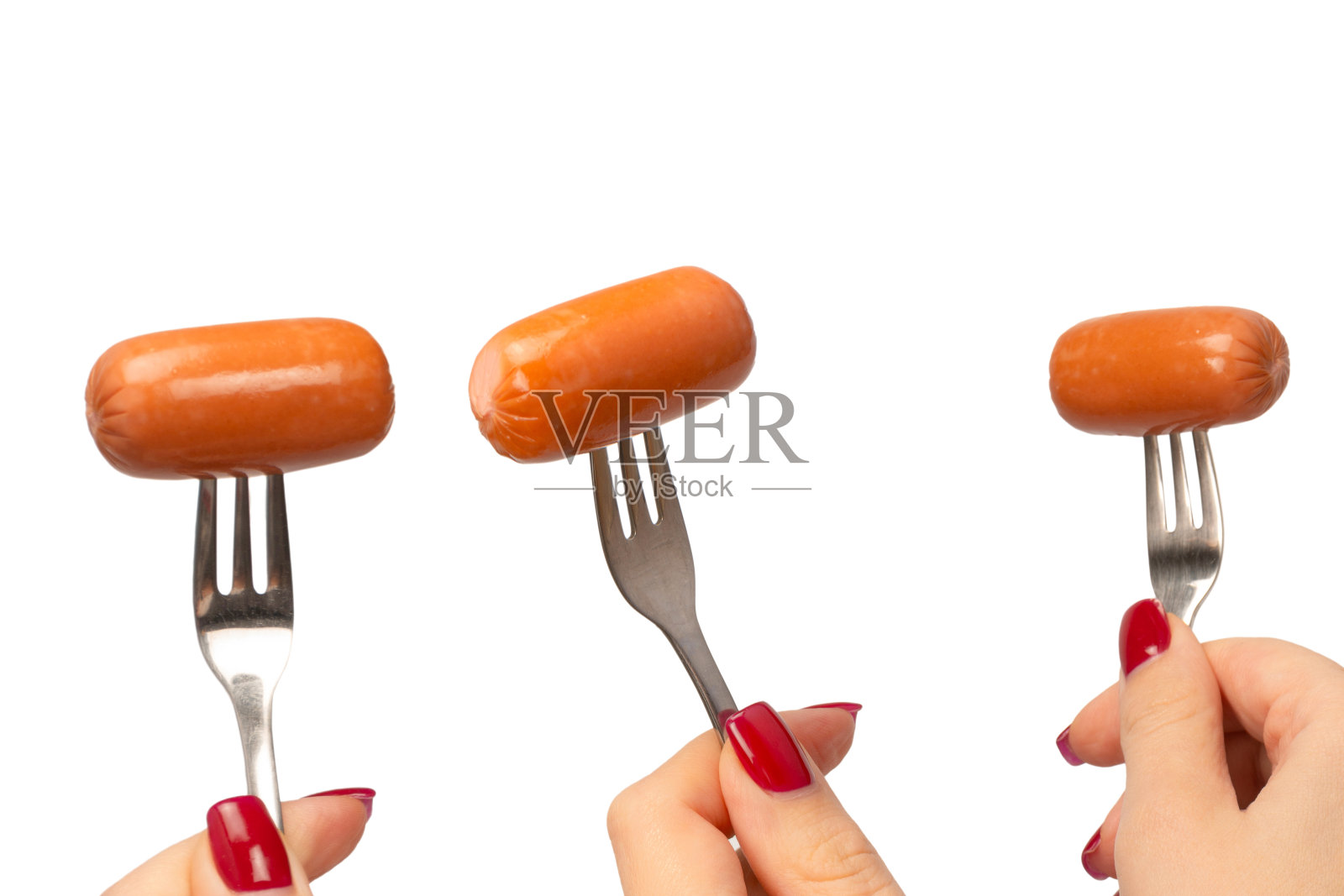 小香肠放在女人手里的叉子上隔离。照片摄影图片