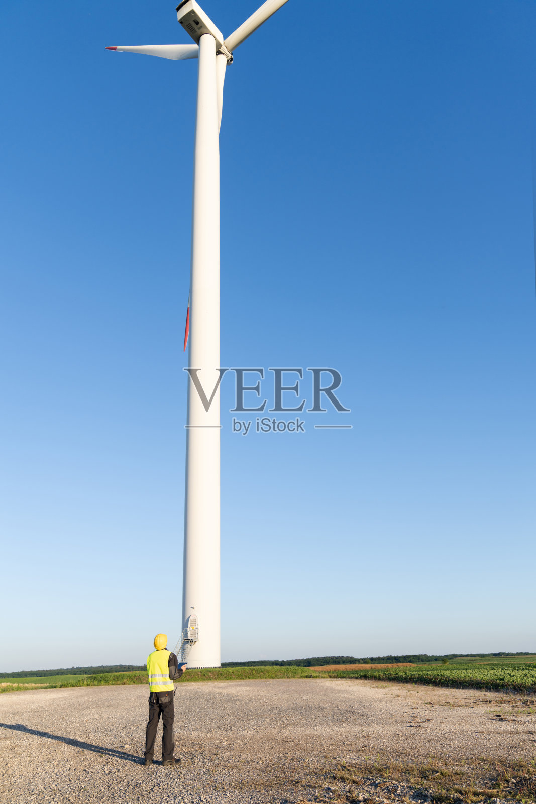 拿着数码平板电脑的工程师在风力涡轮机现场工作照片摄影图片