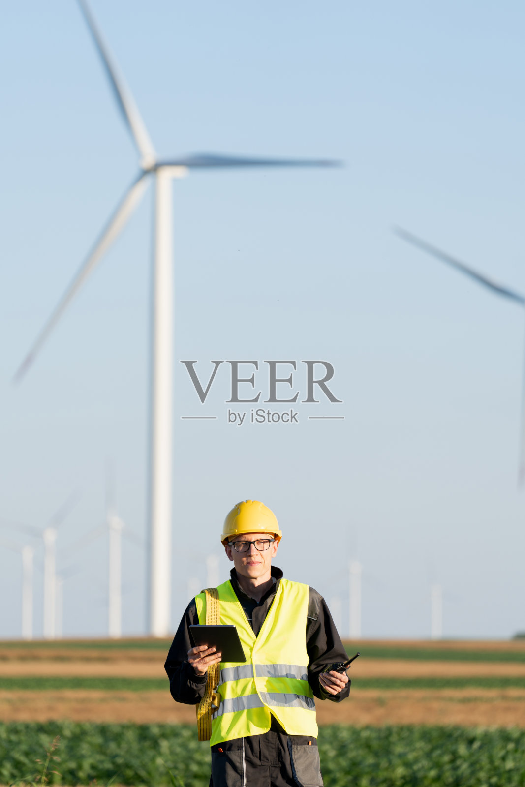 拿着数码平板电脑的工程师在风力涡轮机现场工作照片摄影图片