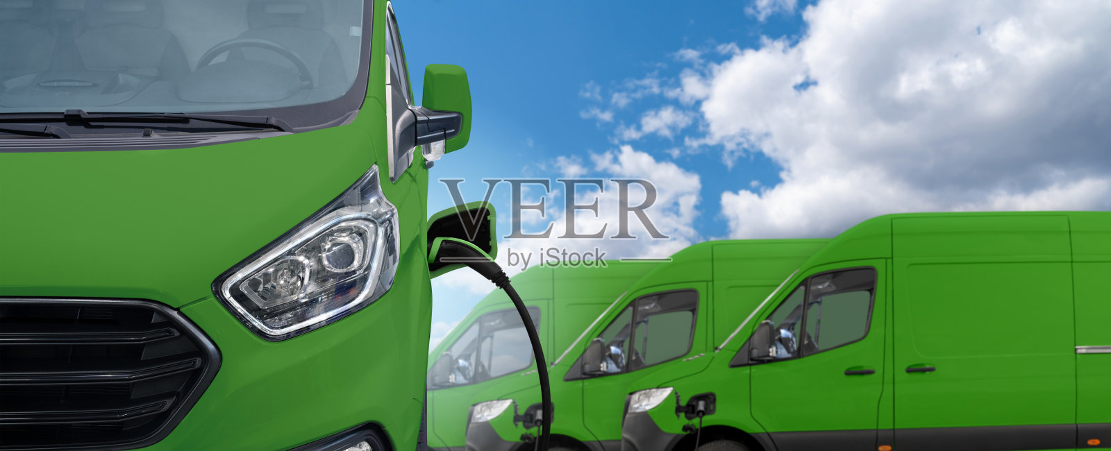 绿色电动送货车，连接充电电缆照片摄影图片