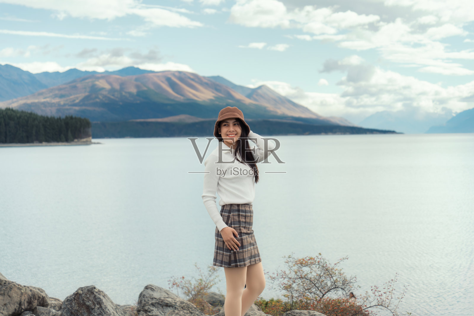 站在新西兰普卡基湖和山脉边的亚洲妇女照片摄影图片