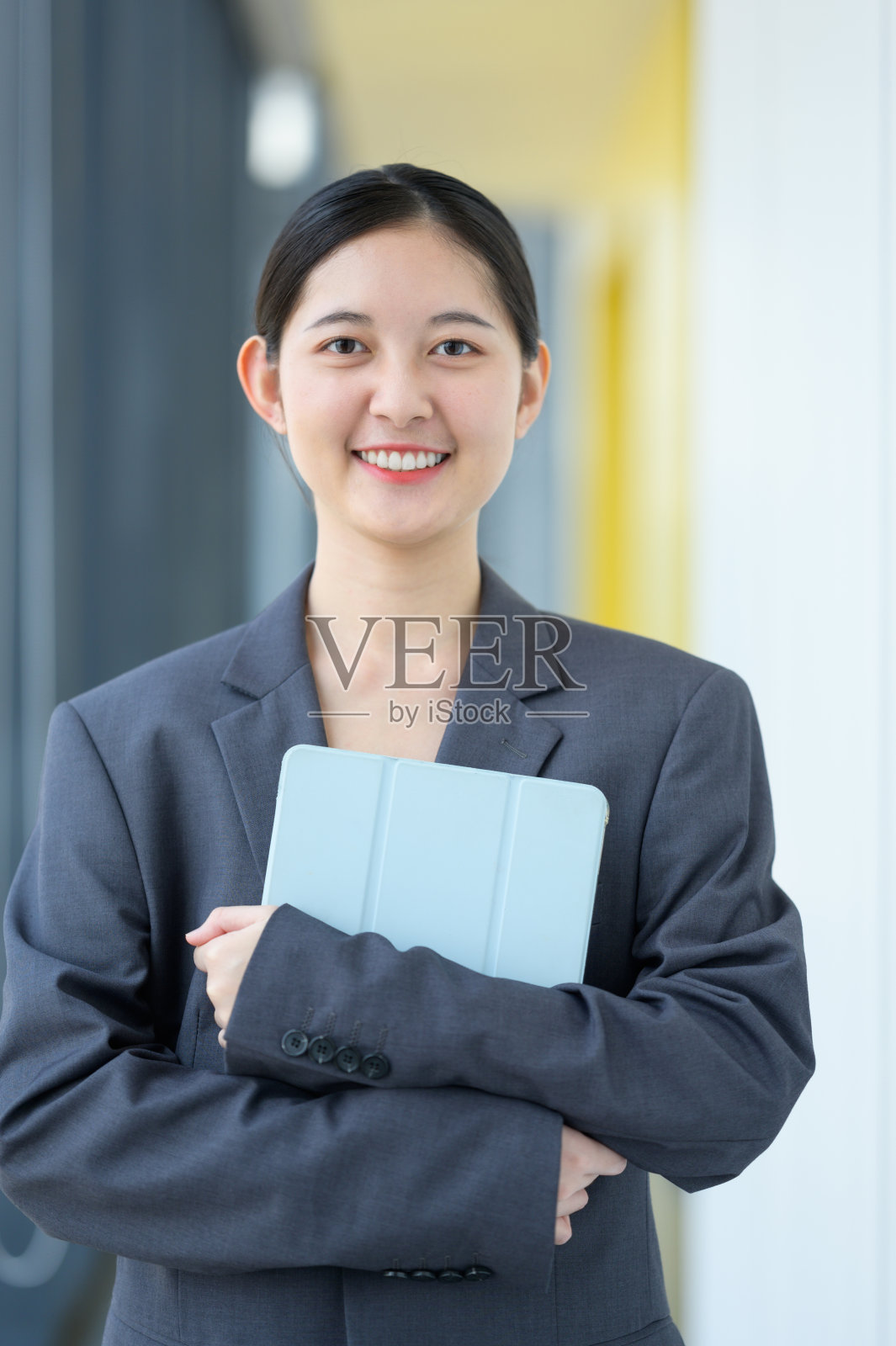 现代Z世代女商人在办公室里拿着数码平板电脑。放松，亚洲女商人在办公室用笔记本电脑工作。照片摄影图片