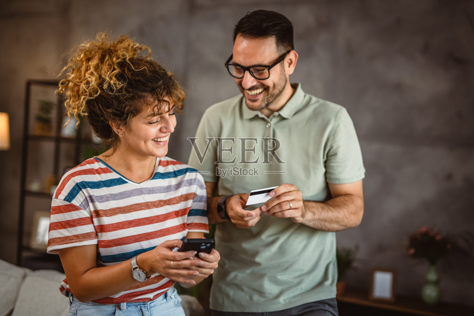 快乐放松的夫妇在家里用手机信用卡网购照片摄影图片