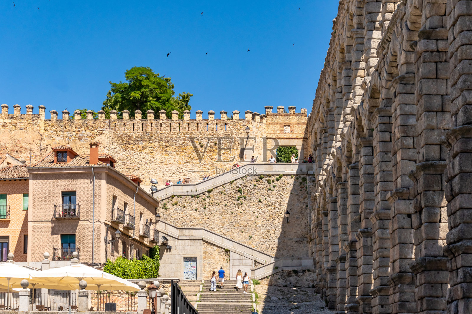 游客在塞戈维亚渡槽散步，这是一座古罗马建筑照片摄影图片