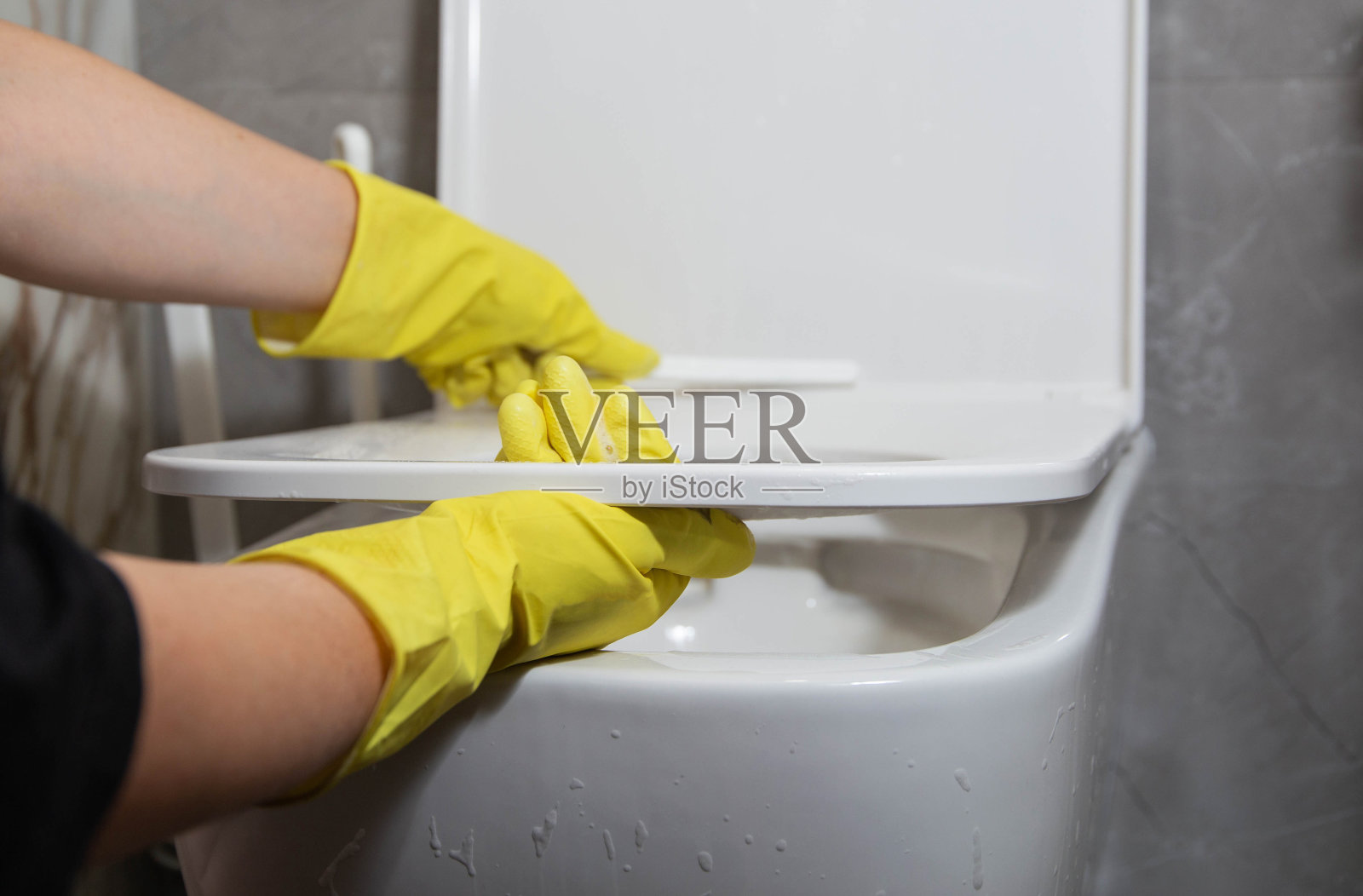 用特殊的刷子和清洗剂清洗马桶圈，去除细菌和污垢。保洁公司服务，特写照片摄影图片