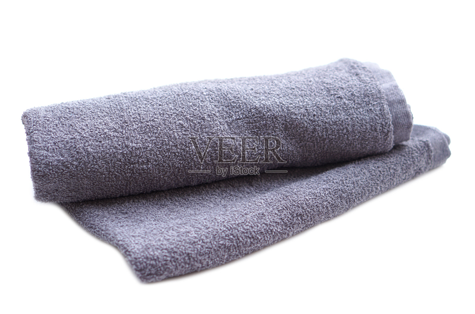 白色背景上的灰色毛巾。理念，衣服在日常生活中使用。用于沐浴、淋浴或水疗按摩的毛巾。照片摄影图片