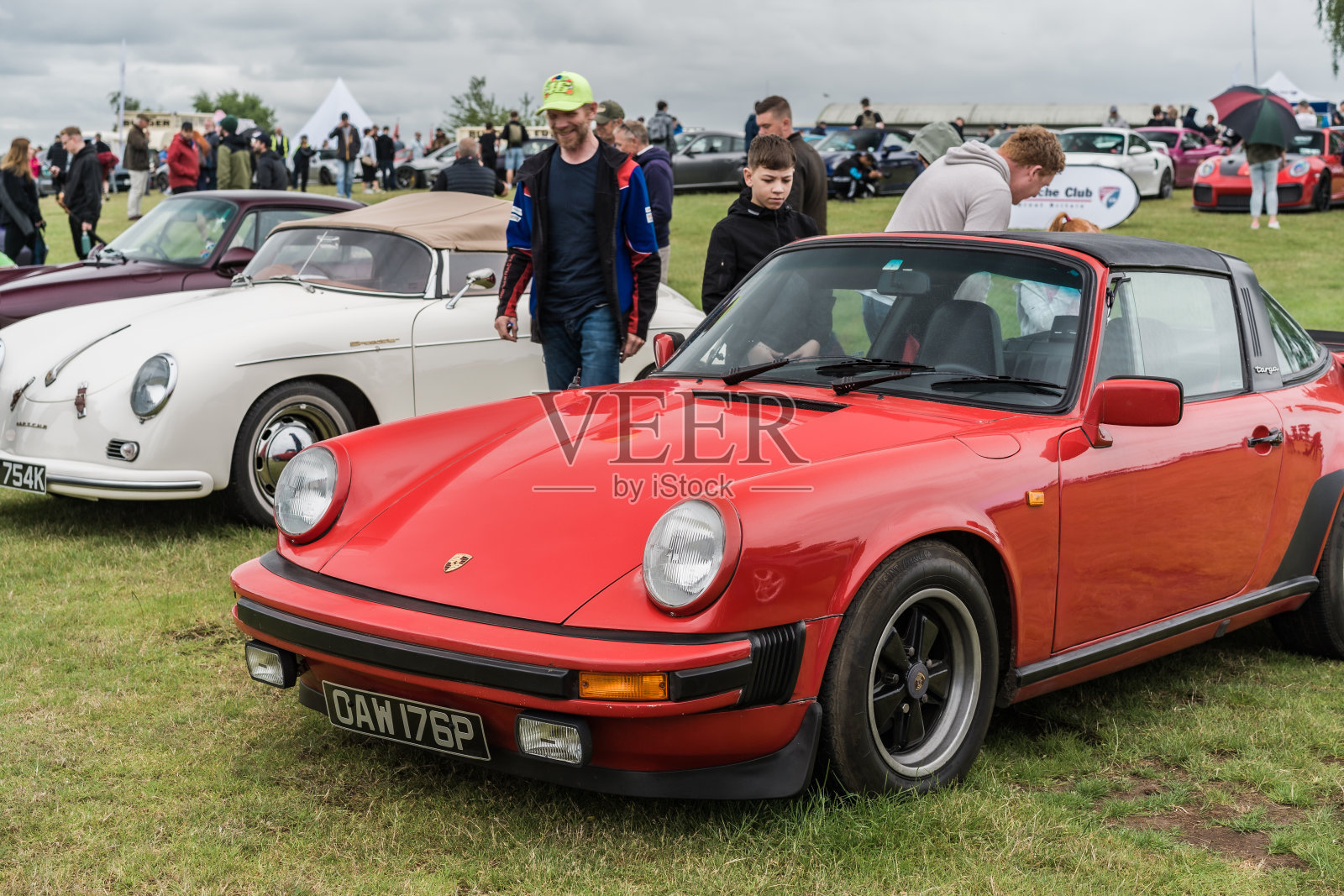 在车展上，人们正注视着一辆红色保时捷911 Targa照片摄影图片