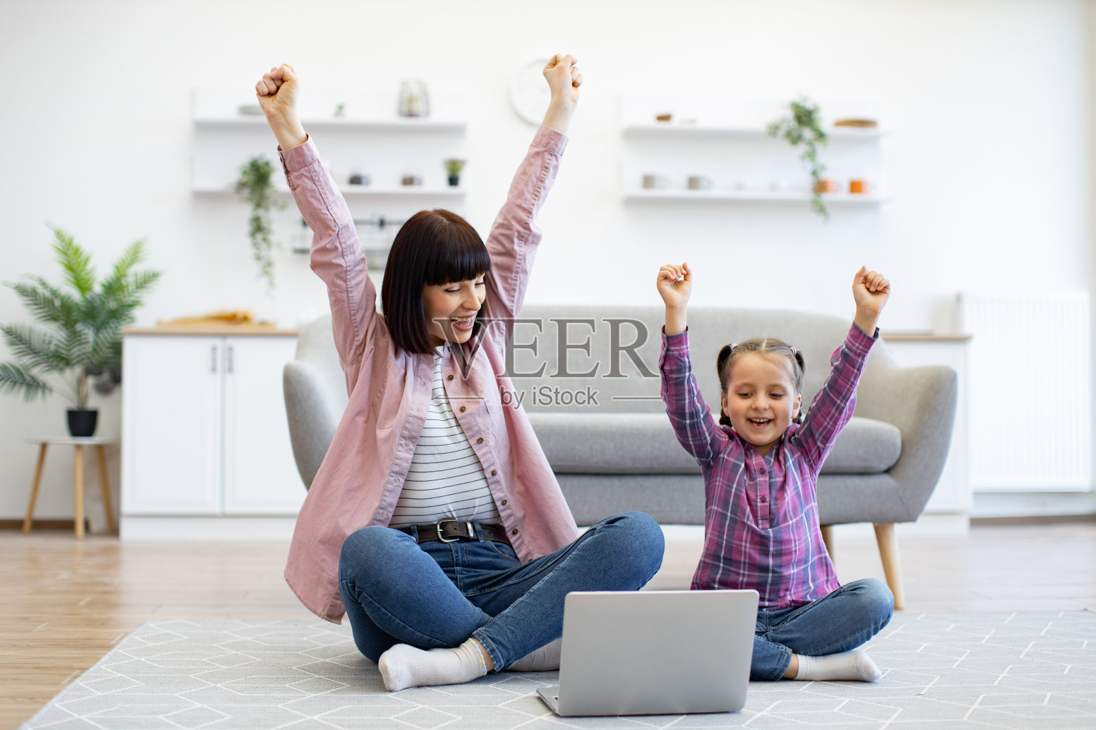 母女俩在家里庆祝成功照片摄影图片