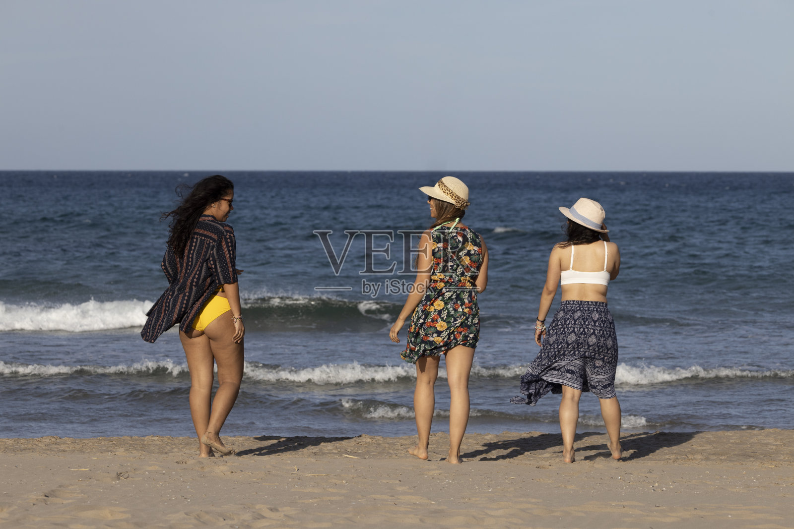 三个女孩躺在海边照片摄影图片