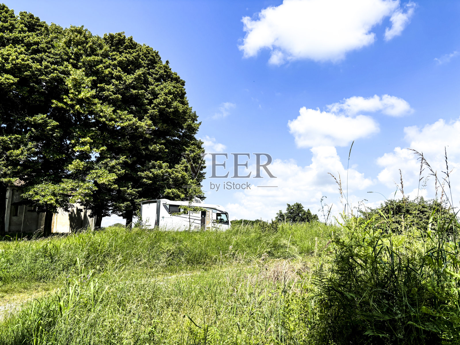 一辆露营车停在乡间的草地上。自由和旅行的另类生活方式。暑假交通工具。Vanlife和离网生活的概念照片摄影图片
