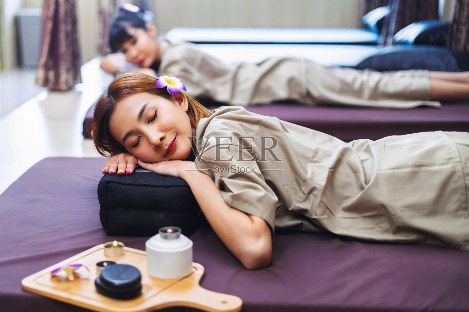 两个女人躺在床上，头上插着花照片摄影图片