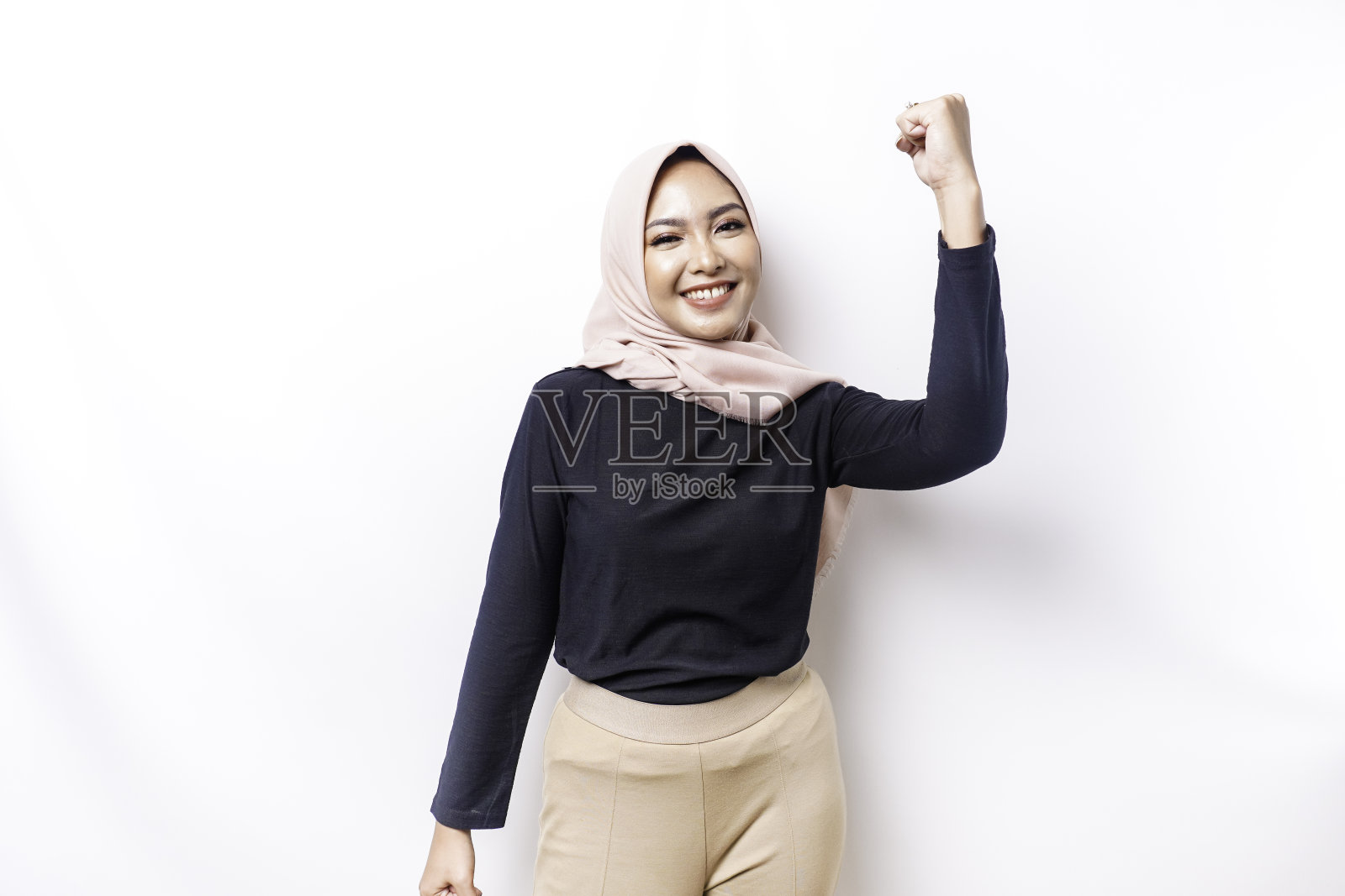 一位年轻的亚洲穆斯林妇女，戴着头巾，被白色背景隔开，脸上带着快乐成功的表情照片摄影图片