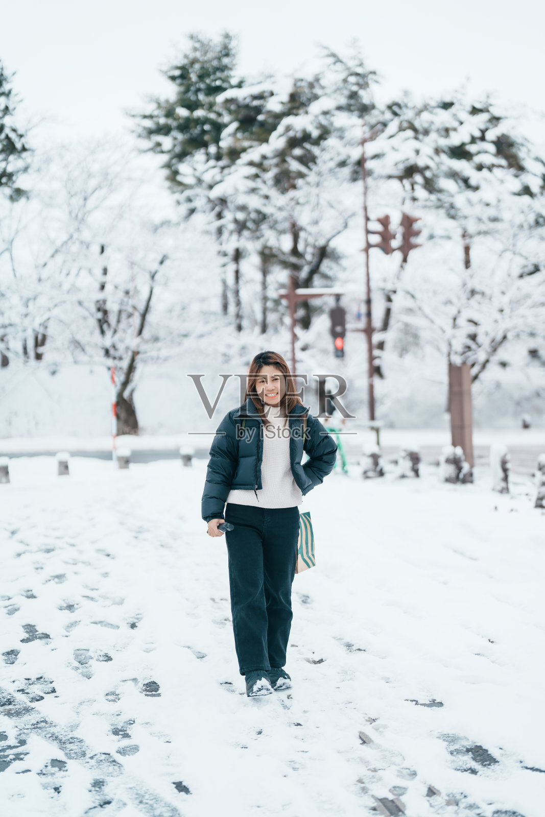在寒冷的天气里，背着毛衣和背包的旅行者走在白雪覆盖的森林里。冬季旅行，冒险，探索和度假的概念照片摄影图片