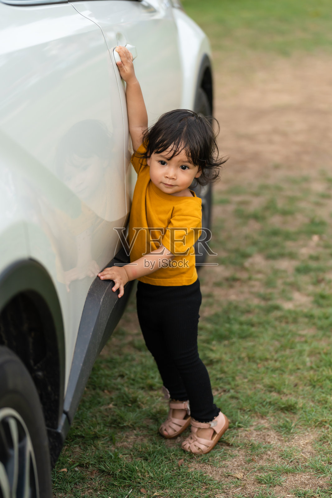 蹒跚学步的女婴打开车门照片摄影图片