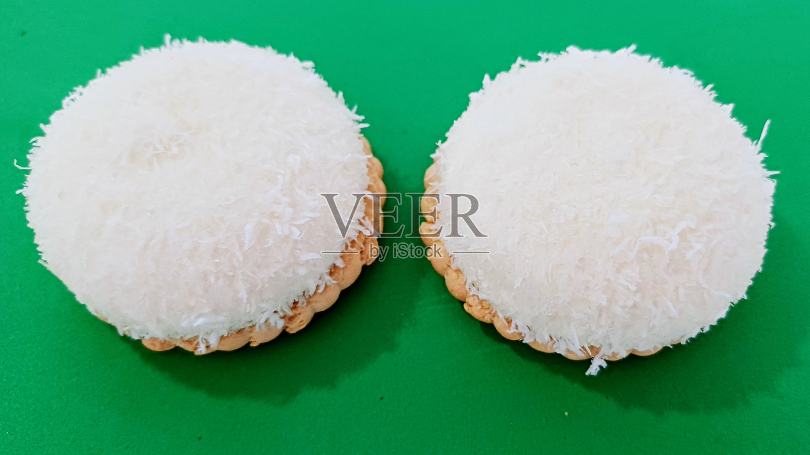 绿色背景上的白色奶油饼干照片摄影图片