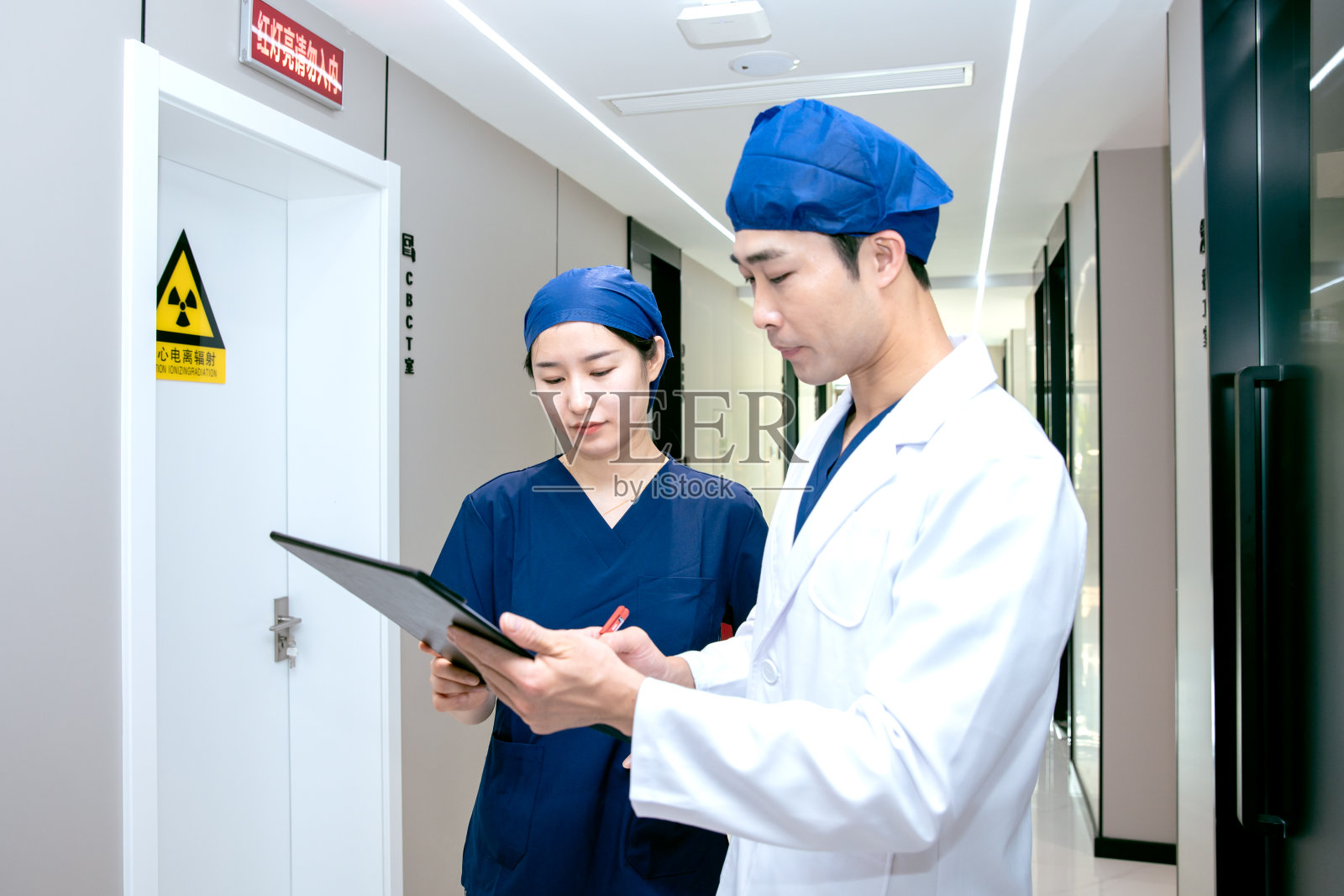 医生和护士在诊所走廊讨论照片摄影图片