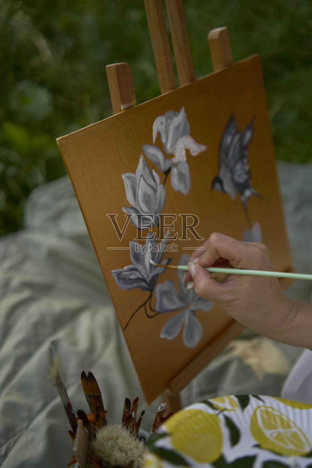 一位穿着白色连衣裙的年轻漂亮的画家在河岸上画画照片摄影图片