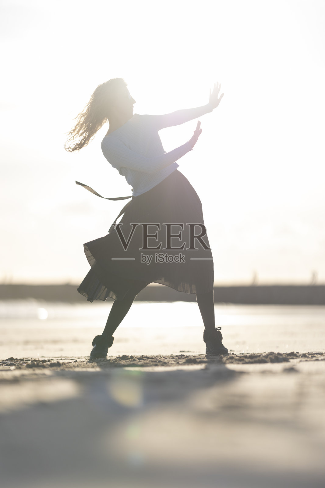 一个女人穿着裙子在沙滩上跳舞照片摄影图片