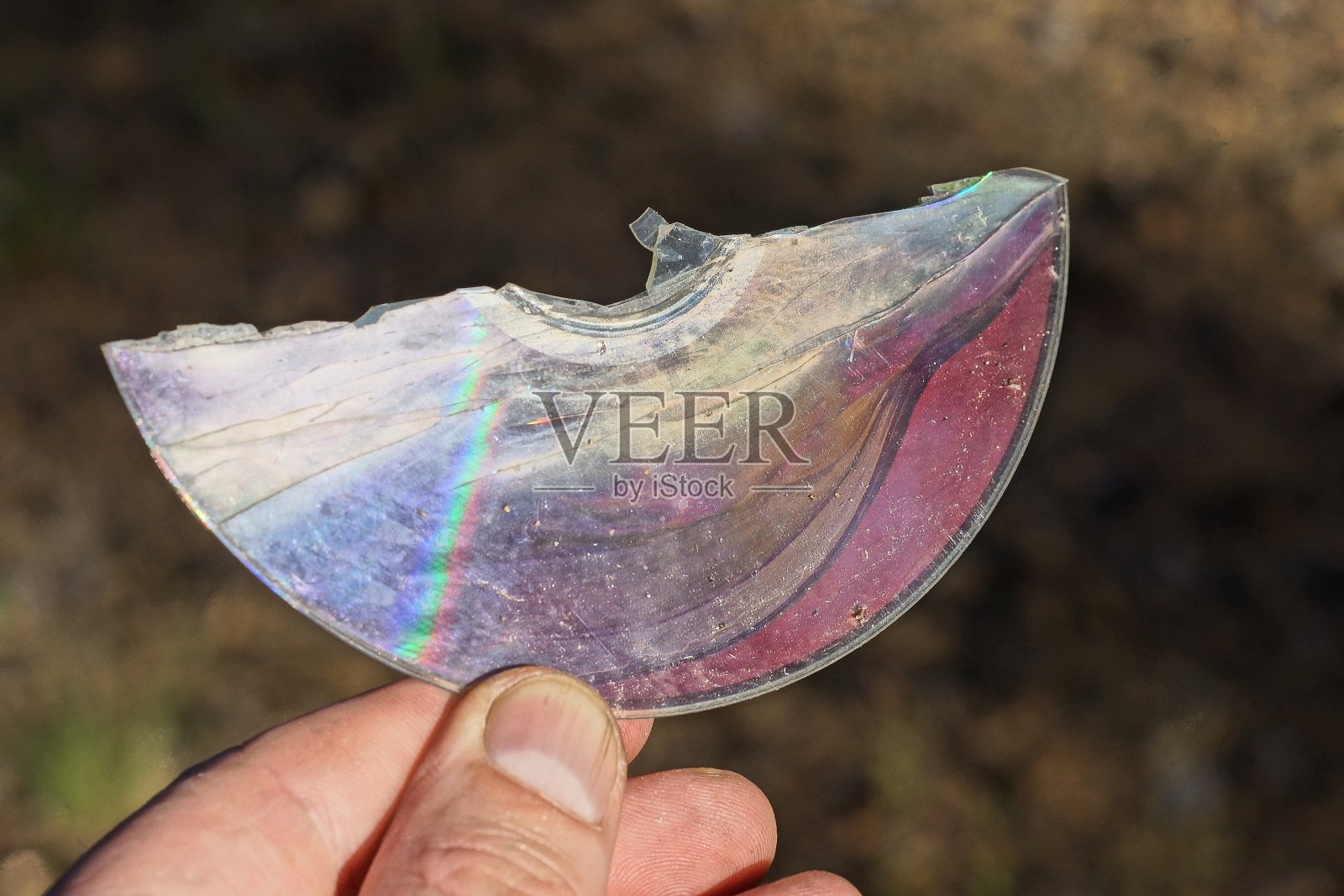 手指握着彩色的破旧光盘照片摄影图片