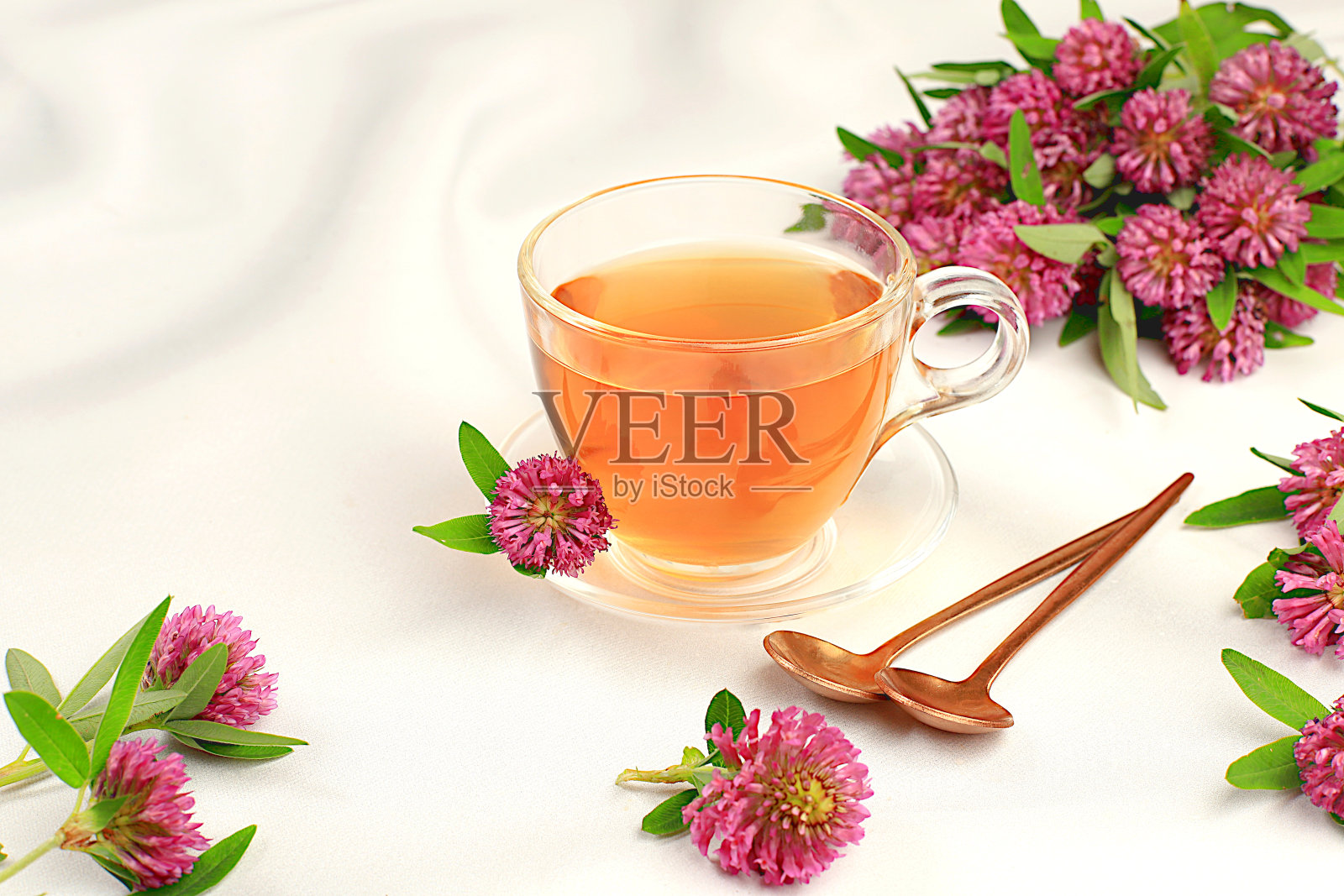 药用草药茶或红三叶草浸泡在一个玻璃杯与花，替代传统医学概念，雌激素来源，更年期治疗，绿色药房广告，照片摄影图片