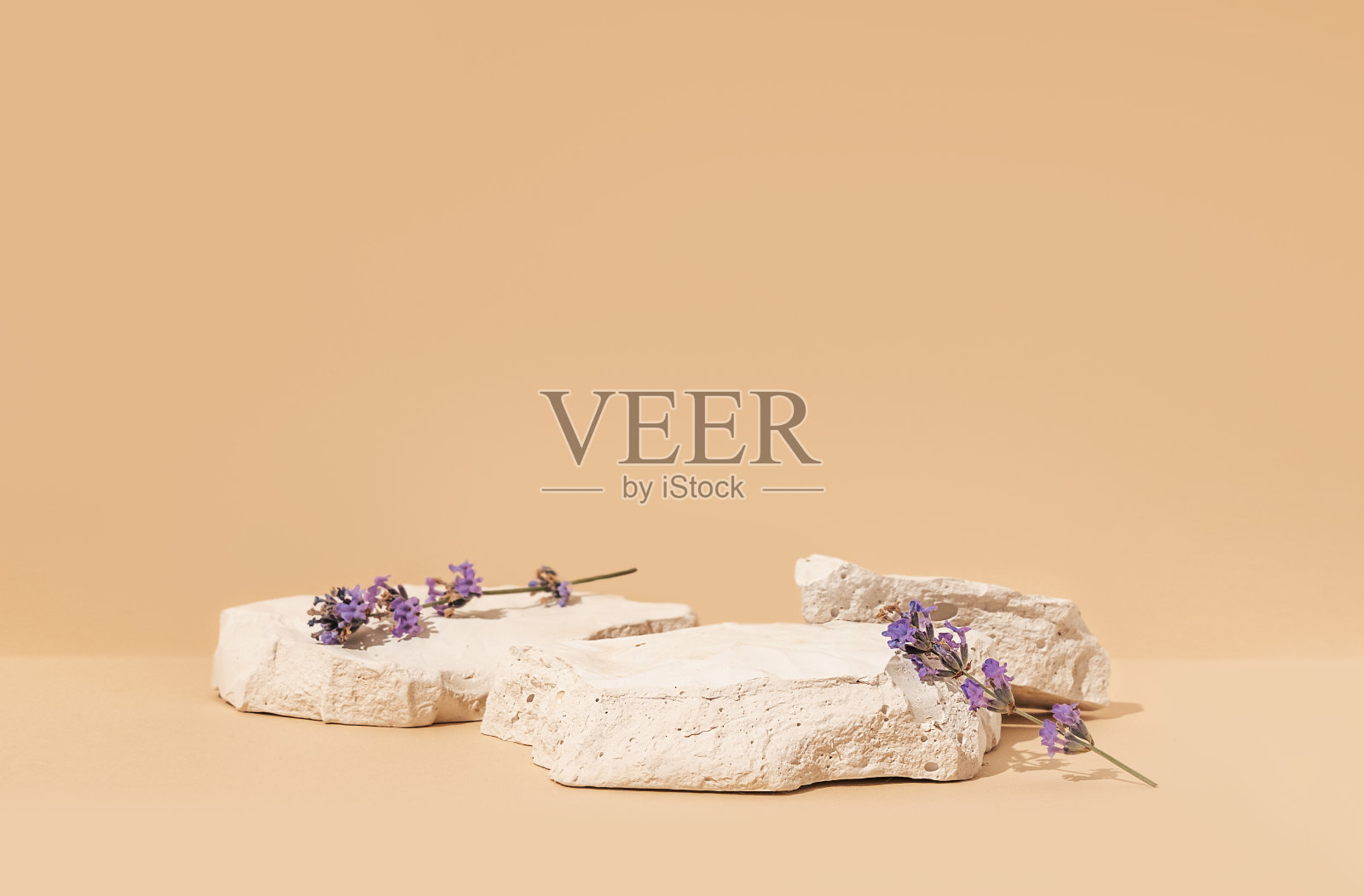 美妆产品模型场景与复制空间，以白色石头和薰衣草花为特色。构图突出了自然的纯净，唤起了夏日的心情。在摄影棚里拍摄。照片摄影图片