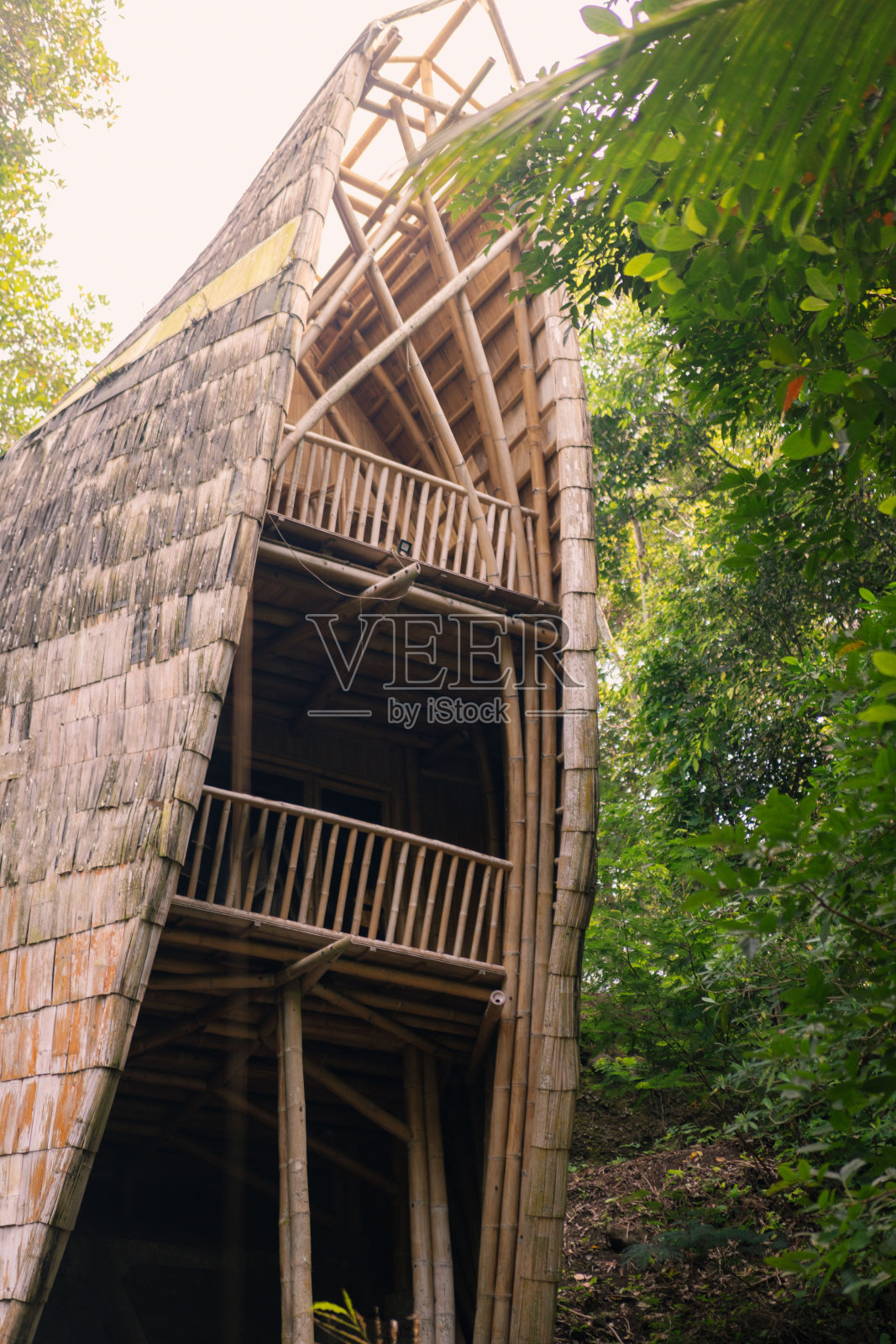 多层竹塔结构，毗邻郁郁葱葱的绿色植物照片摄影图片