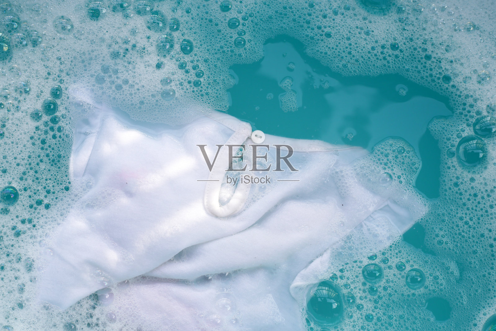 白布浸泡在粉末洗涤剂水中溶解，洗布。衣服的概念照片摄影图片