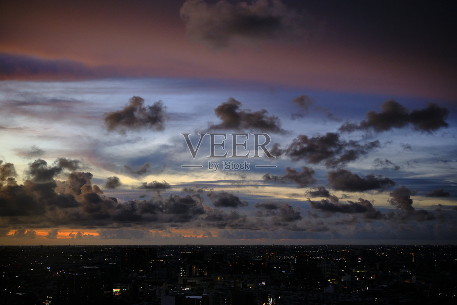 在大雨来临之前，城市美丽风景摄影的天际线日落。大自然的天空充满了云彩。一边是彩云，一边是乌云照片摄影图片