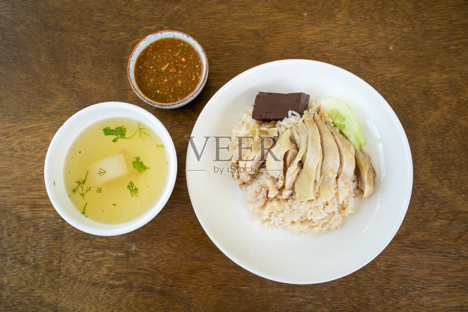 木桌上的鸡饭配蘸酱和汤照片摄影图片