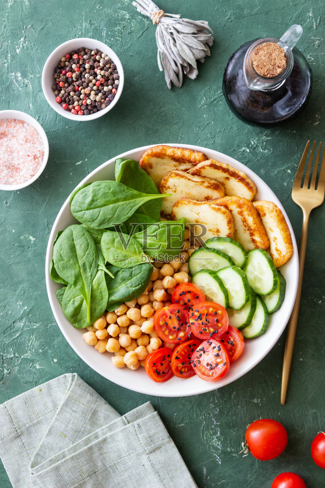配上烤哈卢米奶酪、菠菜、鹰嘴豆、西红柿和黄瓜。健康饮食。素食。饮食。照片摄影图片