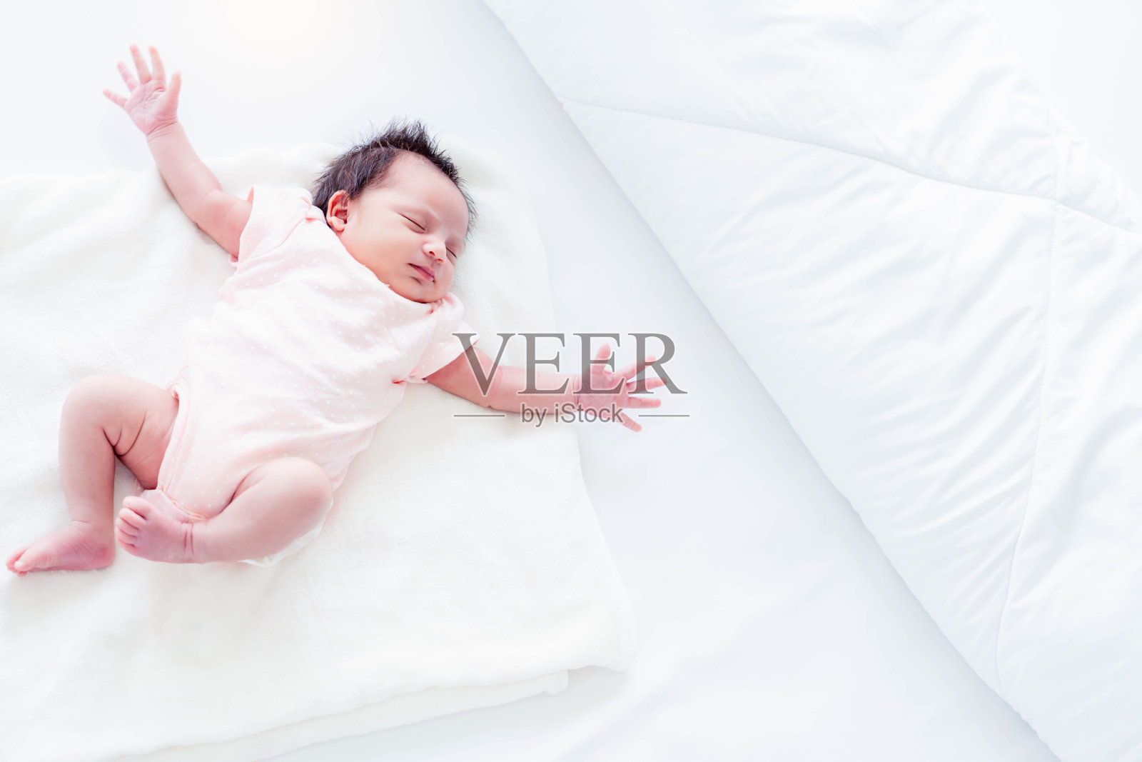 肖像可爱的新生宝宝快乐的做梦伸展和慵懒的伸展在家里的床上俯视图小女孩宝宝躺在床上做好梦睡好觉小女孩身体健康照片摄影图片