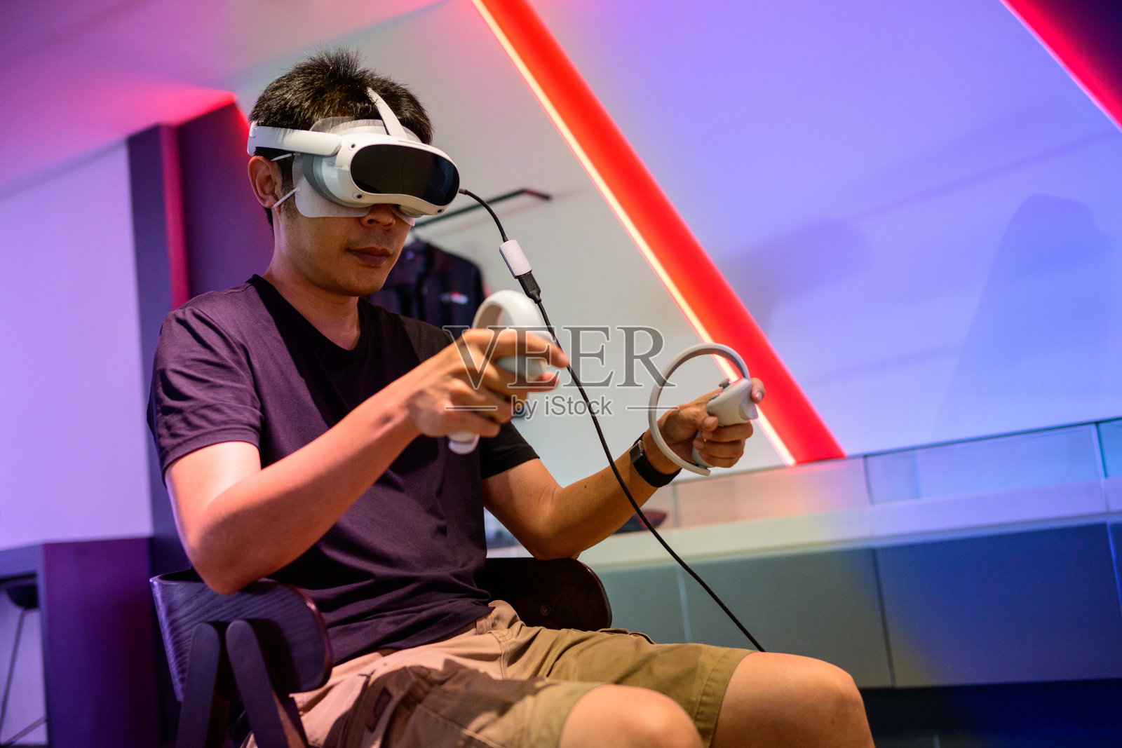 沉浸在乐趣中:一个亚洲男人在家里的VR冒险照片摄影图片