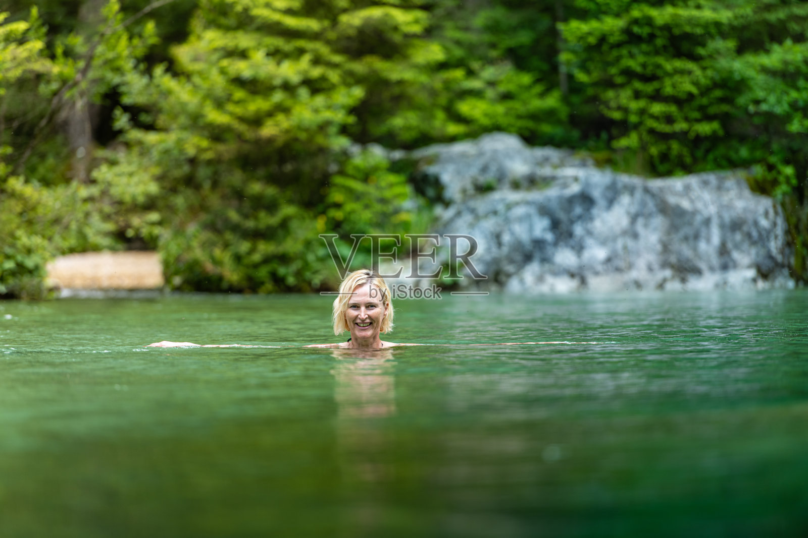 在冰山水中游泳的女人照片摄影图片