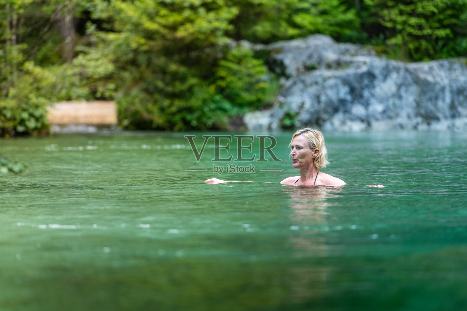 在冰山水中游泳的女人照片摄影图片