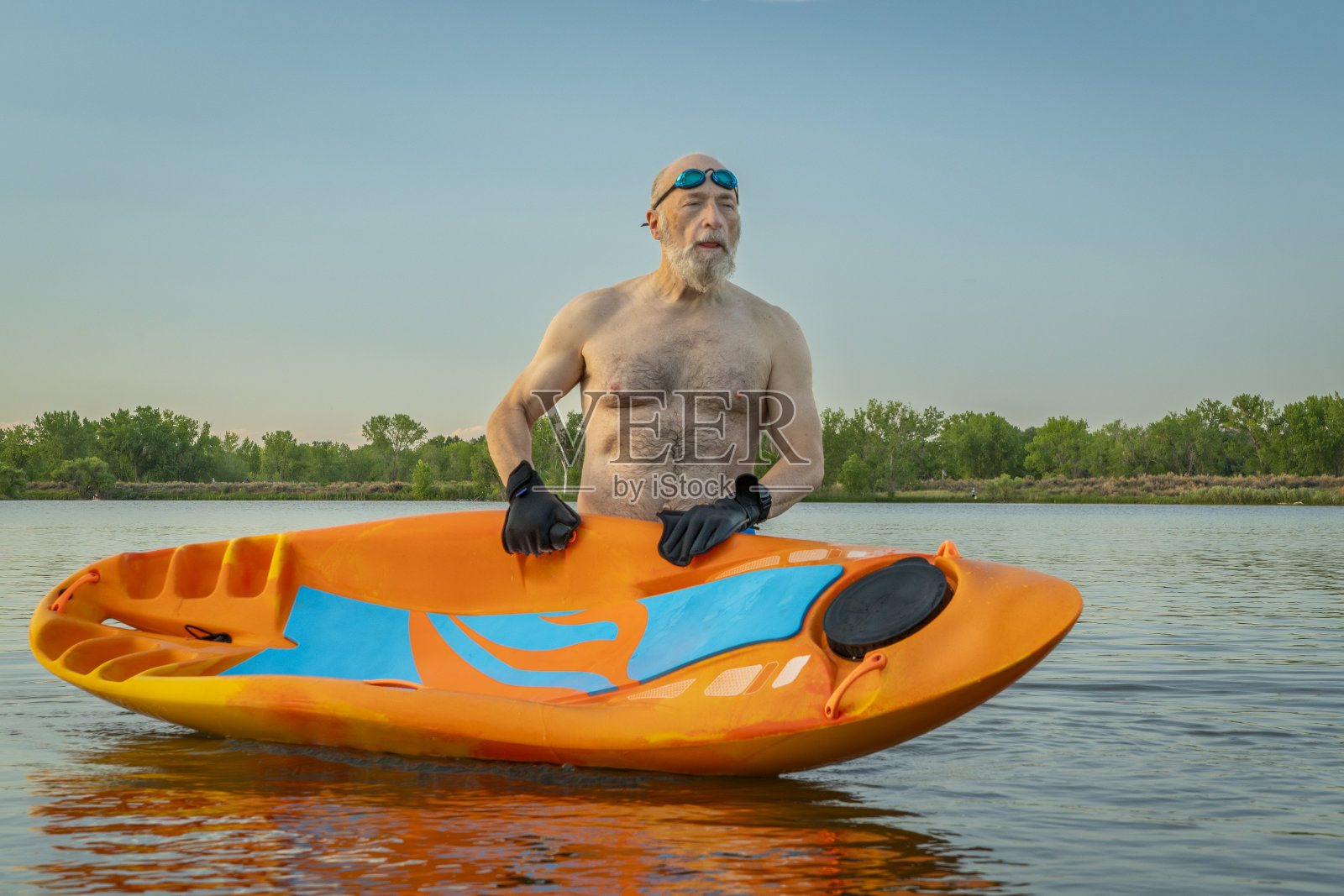 在科罗拉多州的一个湖上，一名运动健将在独木舟上划船，这项水上运动结合了皮划艇和游泳的各个方面照片摄影图片