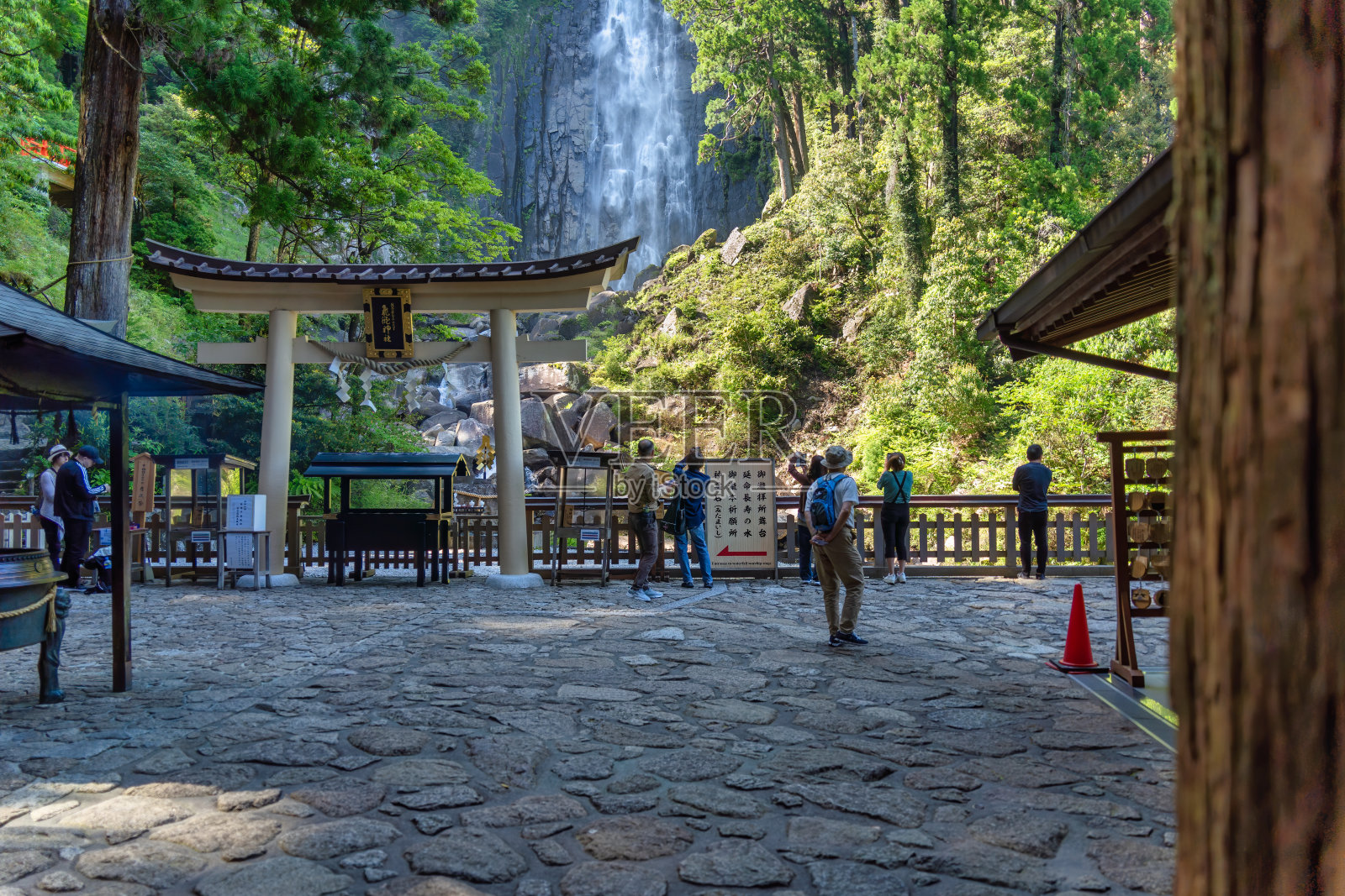 游客在Nachi瀑布底部。宽神社，熊野古多朝圣路线的终点。照片摄影图片