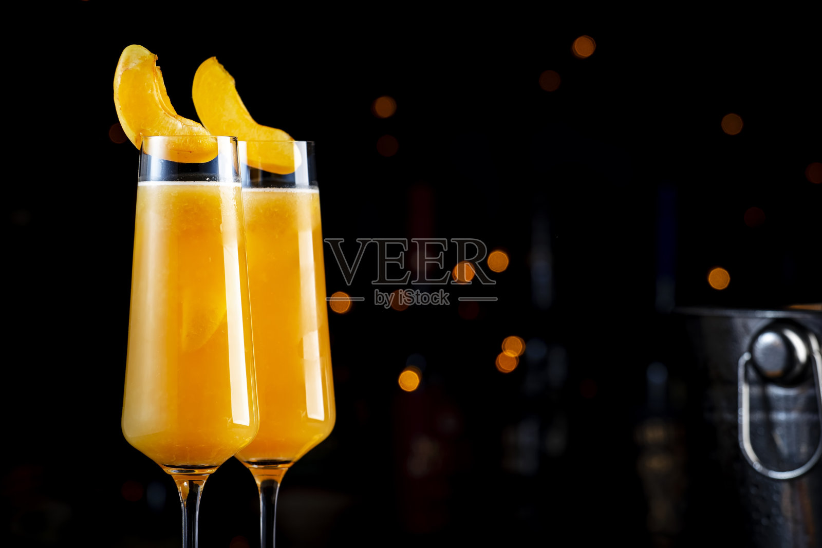 杏贝利尼酒精鸡尾酒与普罗赛克，卡瓦酒，或起泡酒与杏泥，糖浆和冰，深色吧台背景，复制空间照片摄影图片