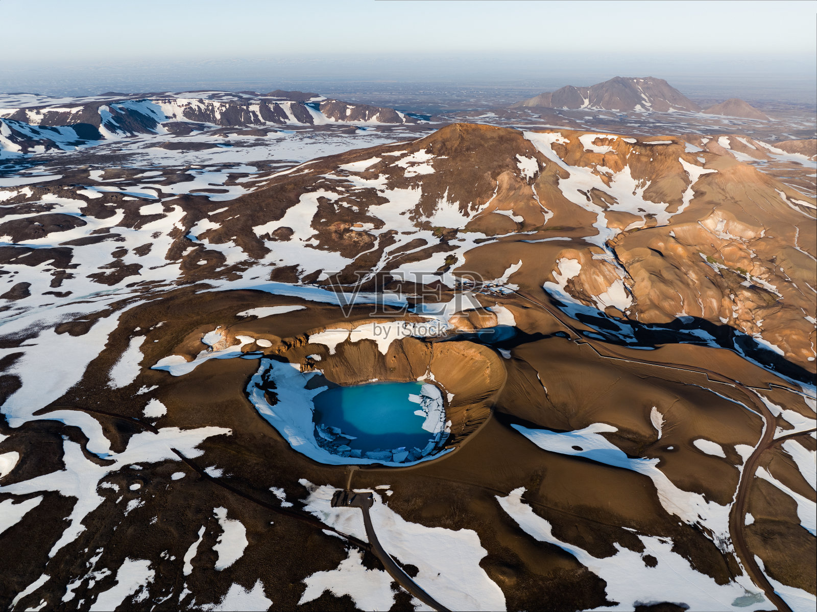 从空中俯瞰，克拉夫拉维提陨石坑令人惊叹的鸟瞰图。这个美丽的火山口充满了蓝色的水，周围是地热区和五颜六色的山脉。冰岛。照片摄影图片