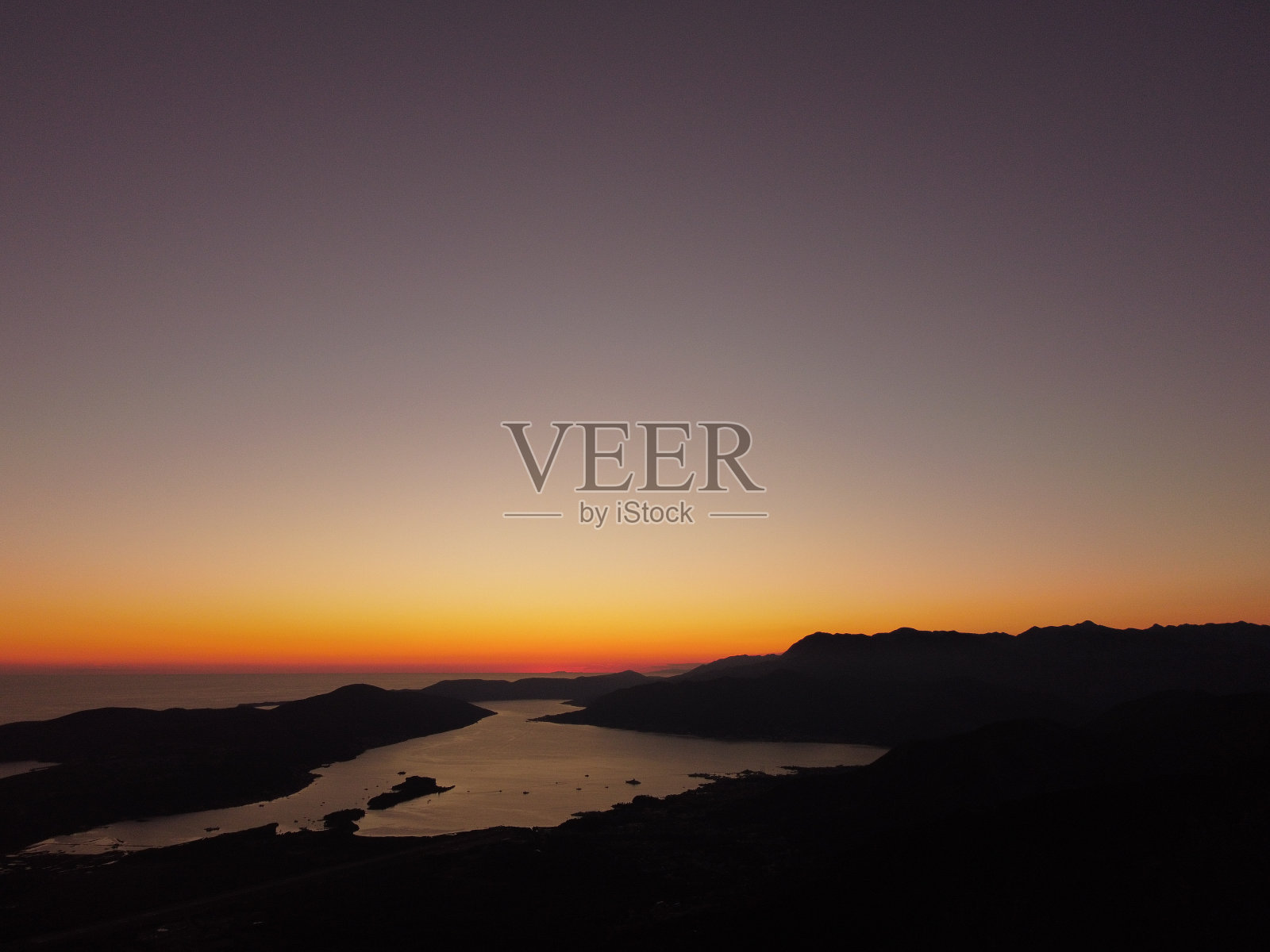 在黑山亚得里亚海科托尔湾，空中无人机拍摄美丽的日落或日出景观，天空晴朗。宁静的天际线与明亮的橙色阳光。暑假概念照片摄影图片