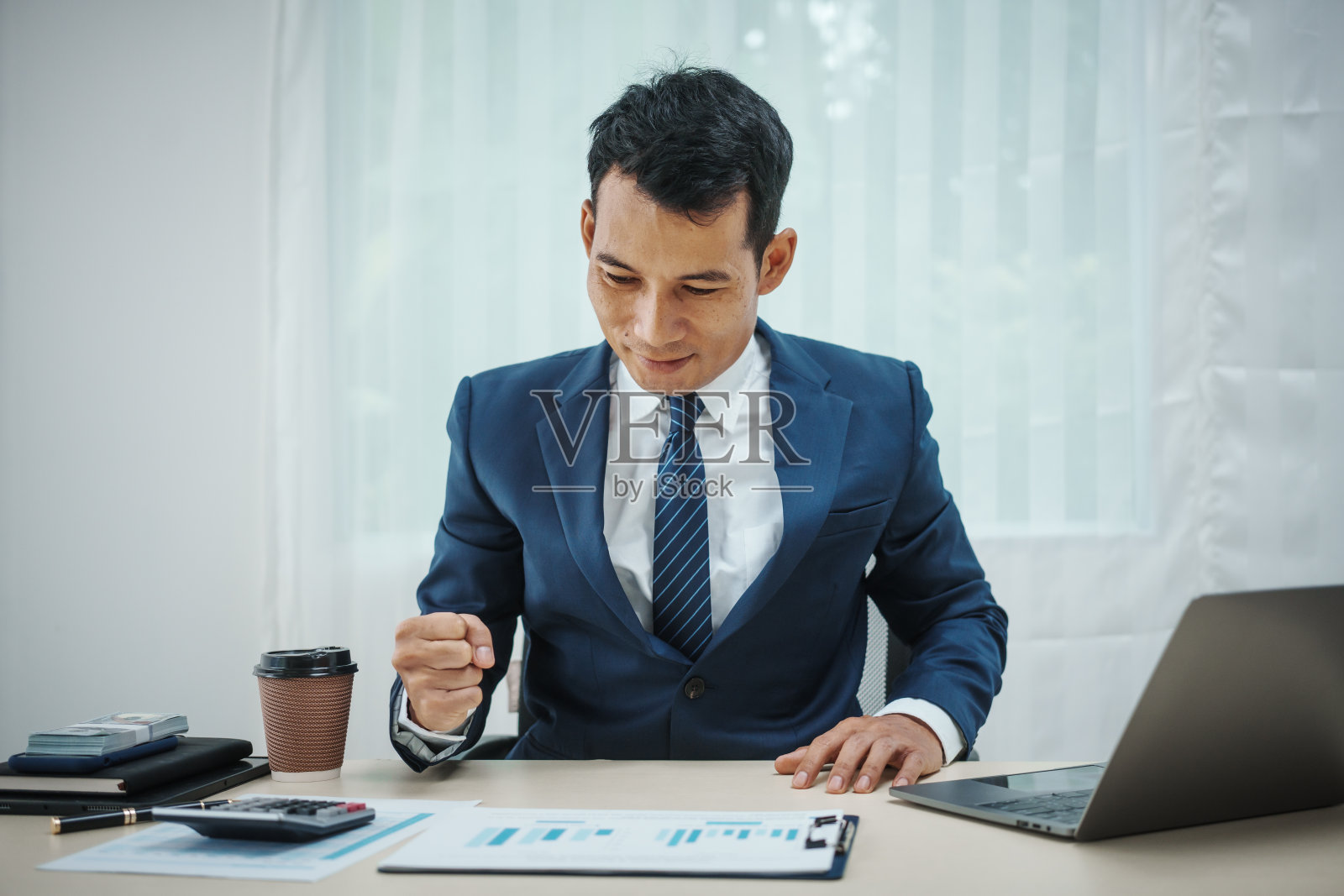 西装革履的银行家在办公桌前工作，处理贷款、分析客户金融数据、提供金融建议、处理股票、研究经济形势。经济压力来自照片摄影图片