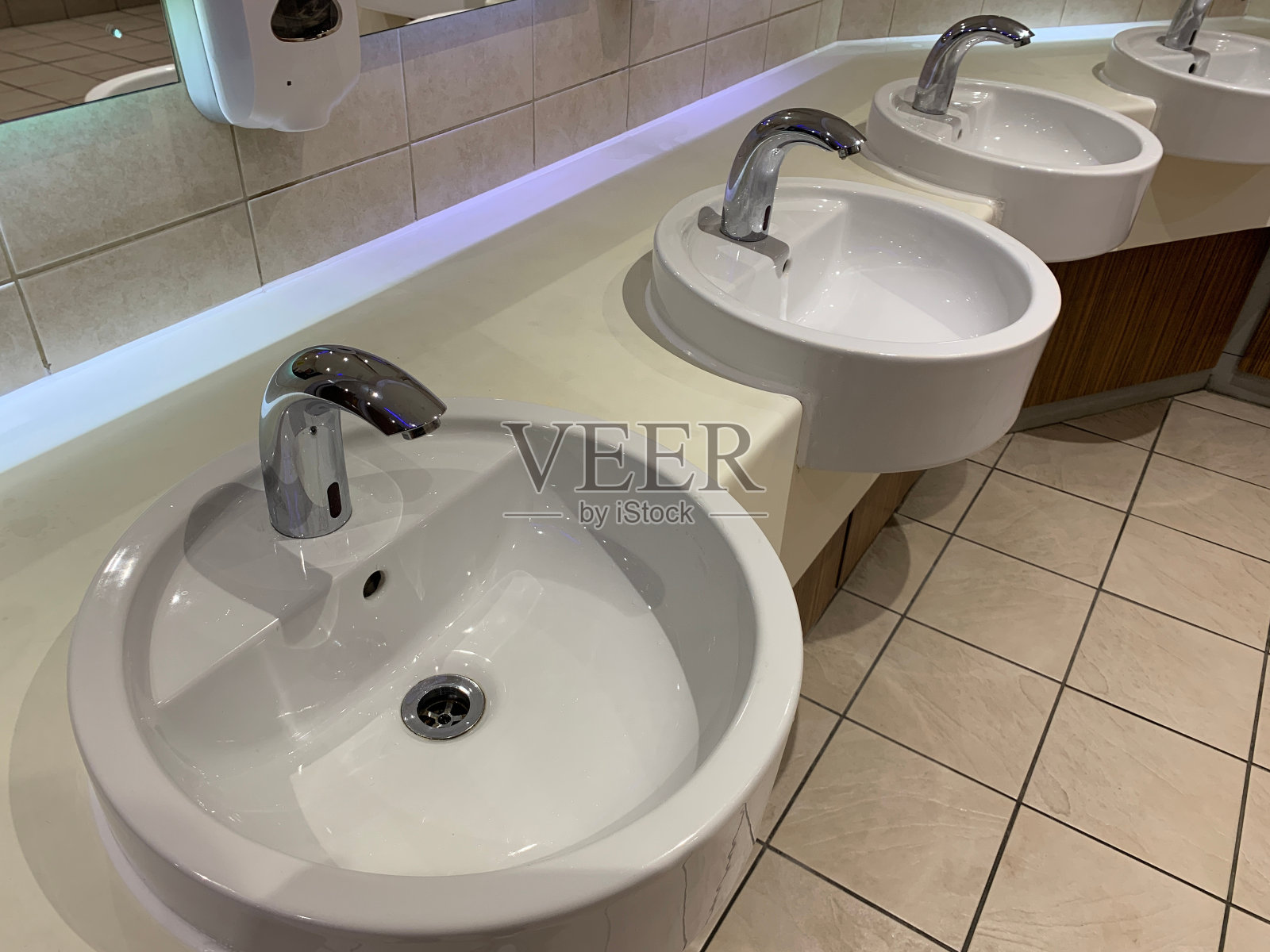 白色水槽配有单个银色水龙头，当手靠近传感器时自动启动水龙头照片摄影图片