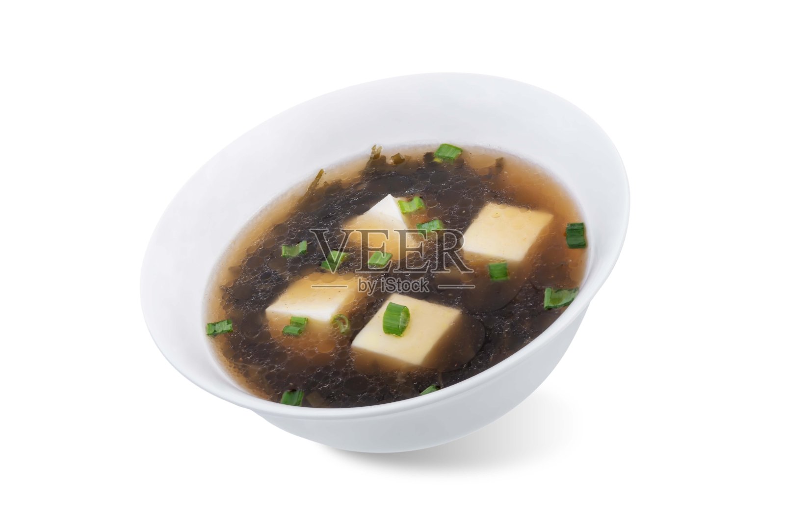 碗里放着豆腐和葱的海藻汤，背景是白色的照片摄影图片