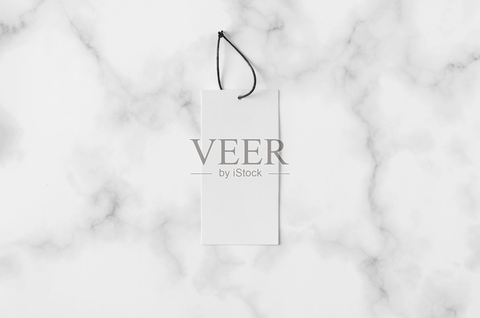 矩形衣服标签，白色大理石背景上的礼物标签模型。照片摄影图片